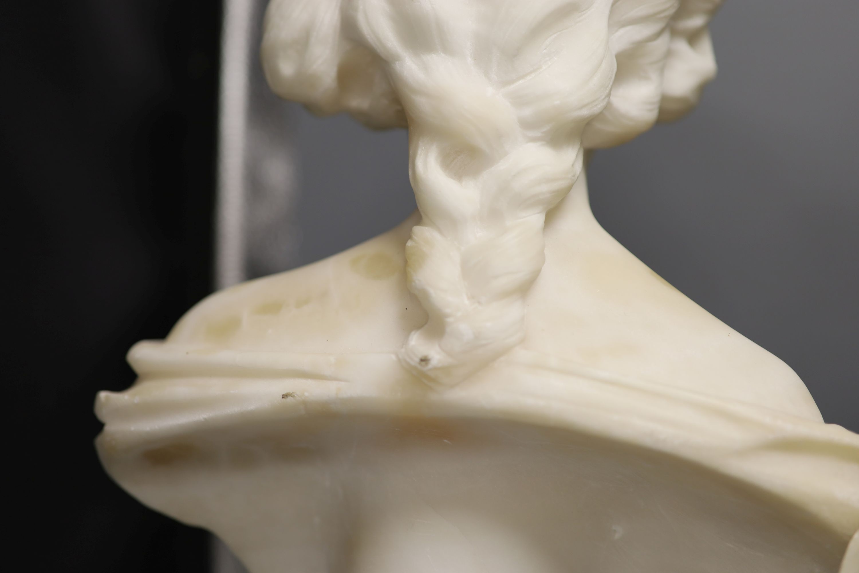 Two white alabaster busts of young women, raised on turned plinths 44cm